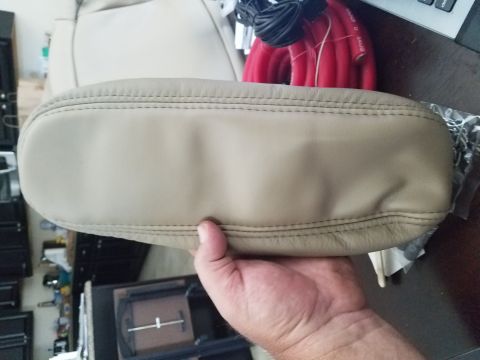 1994 Ford Bronco - Close-up of a tan leather armrest, likely a car interior part, with visible stitching.