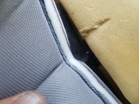 1994 Ford Bronco - Detail of damaged seat foam and fabric, showing the interior construction of a vehicle seat.