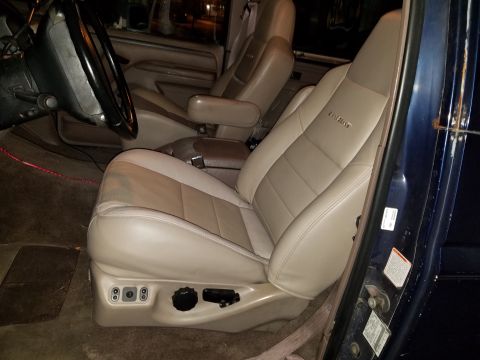 1994 Ford Bronco - Interior view of a vehicle's front seats, showing two-tone leather upholstery and power seat controls.
