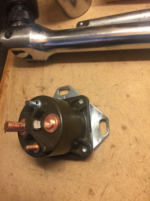 1989 Ford Bronco - Starter solenoid and a ratchet wrench are shown on a wooden surface.