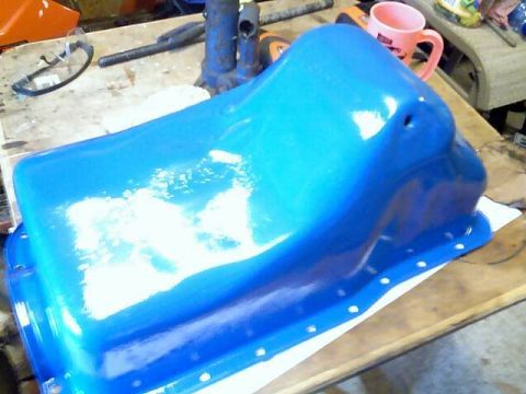 1989 Ford Bronco - A freshly painted blue oil pan sits on a workbench, ready for installation.