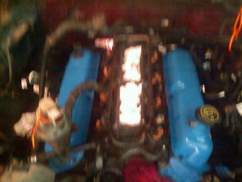 1989 Ford Bronco - Close-up view of an engine bay bright blue valve covers and exposed fuel injectors.