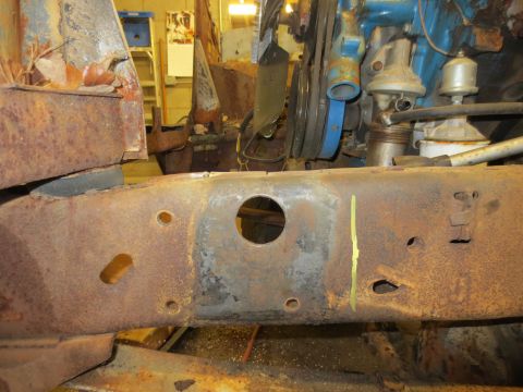 1967 Ford F-250 - The heavily corroded frame of a truck shows signs of wear and tear, with engine components in the background.