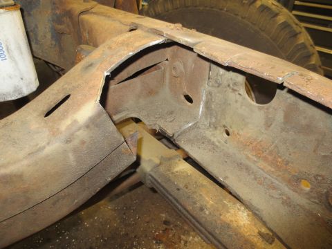 1967 Ford F-250 - Close-up view of a heavily rusted truck frame section, showing structural components and a leaf spring. A white filter is partially visible.