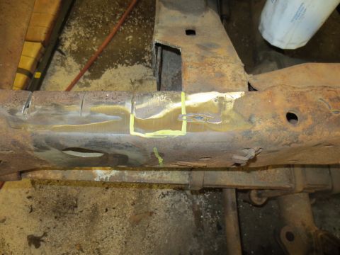 1967 Ford F-250 - Close-up of a heavily rusted vehicle frame section with yellow markings indicating repair areas.
