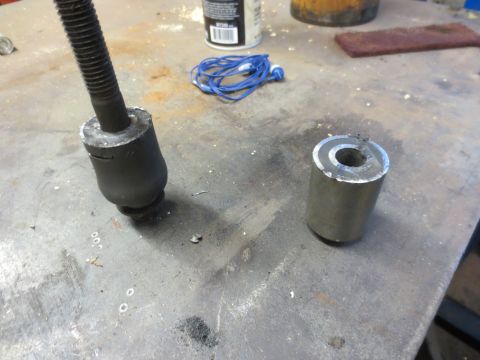 1967 Ford F-250 - Suspension bushing and metal sleeve on a workbench, possibly for a vehicle repair.