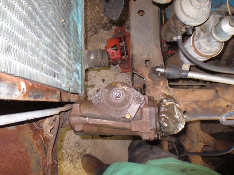 1967 Ford F-250 - Close-up view of a vehicle's steering gearbox and radiator, with a red jack in the background.