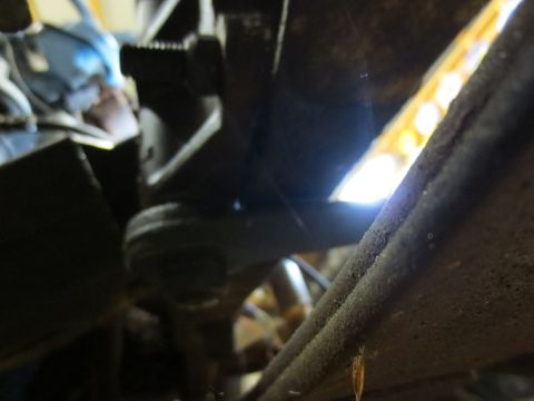 1967 Ford F-250 - Detail of a vehicle's suspension system, showing a metal part and a bright light in the background.