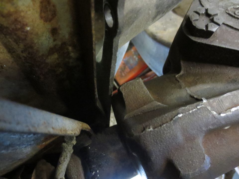 Close-up of rusty metal vehicle steering and suspension parts, showing wear and damage