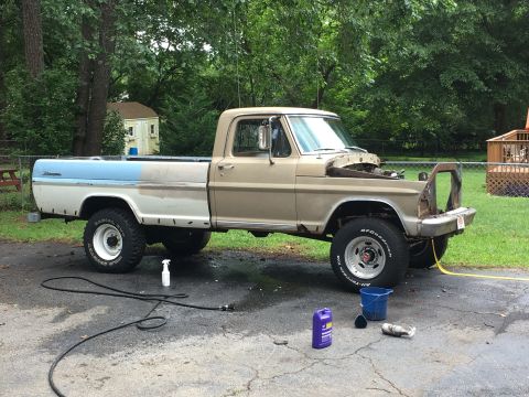 1967 Ford F-250 - A tan and blue Ford F-250 pickup truck is parked outside with its hood removed, possibly undergoing maintenance.