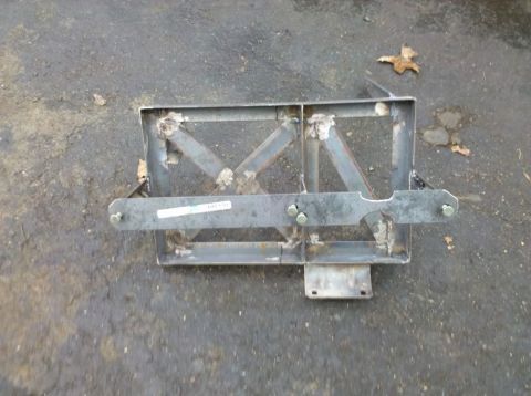 1989 Ford Bronco - This is a custom metal bracket, likely for a vehicle part, shown outdoors on a paved surface.