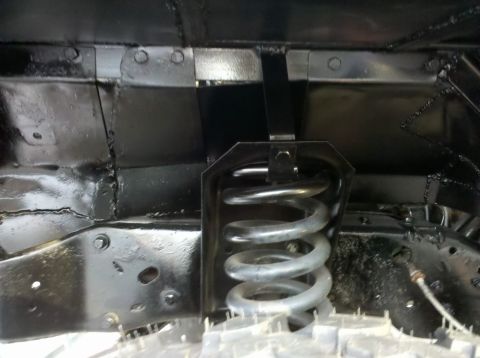 1989 Ford Bronco - Undercarriage view shows a suspension coil spring and painted frame components.