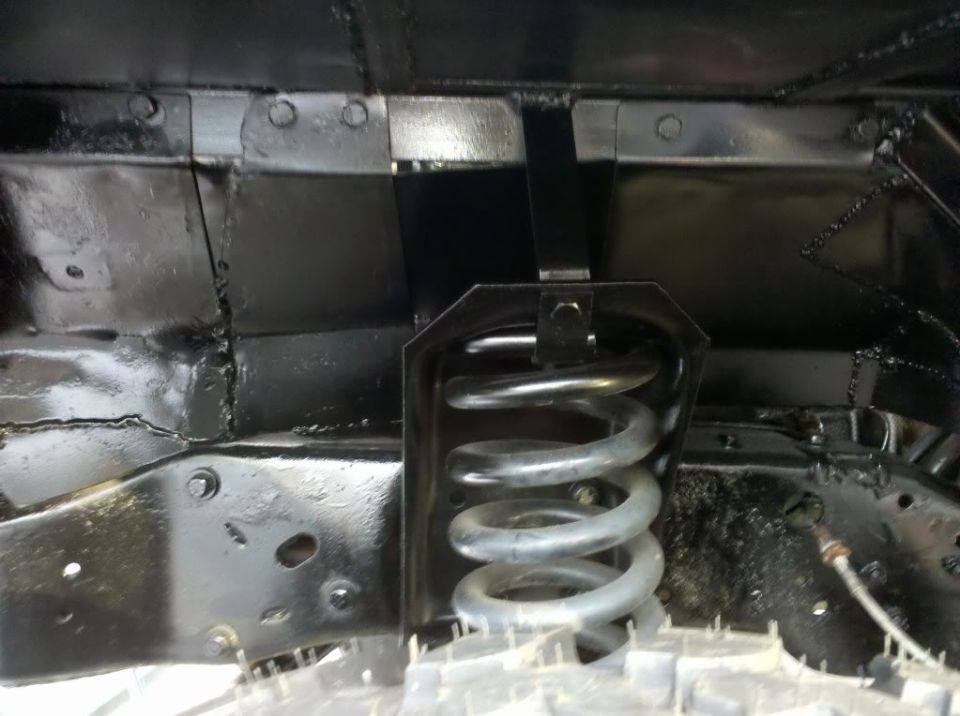 close-up of a vehicle's front suspension coil spring and frame