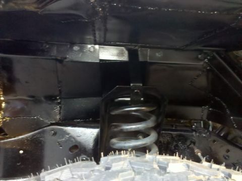 1989 Ford Bronco - Close-up view of the undercarriage of a vehicle, showing the frame and suspension components.