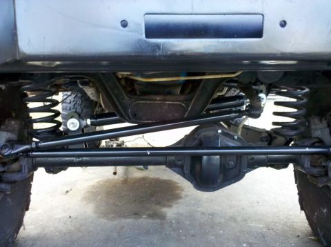1989 Ford Bronco - Close-up of the front axle and steering system, showing the tie rod and drag link.