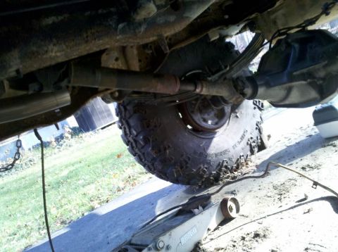 1989 Ford Bronco - The underside of a vehicle is shown, with a tire and suspension components visible.
