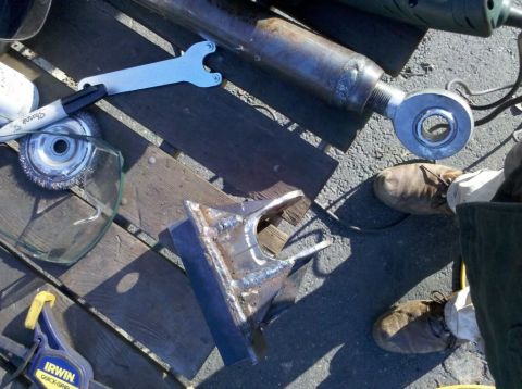 1989 Ford Bronco - Tools and metal parts laid out on a wooden surface, possibly for a welding project.