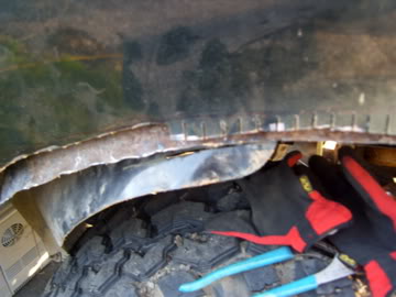 1989 Ford Bronco - Close-up view of rust damage and repair work in a vehicle's wheel well, with the SuperMotors logo in the corner.