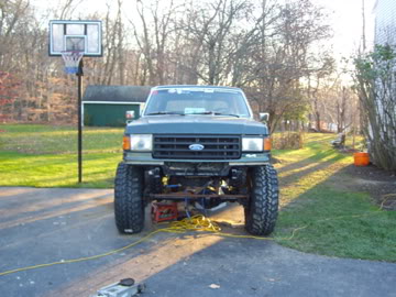 1989 Ford Bronco - Front view of a lifted 1989 Ford Bronco with large tires, parked in a driveway.