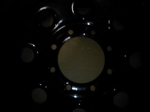 1989 Ford Bronco - Black wheel rim with visible lug nut holes.