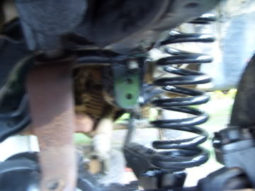 1989 Ford Bronco - Close-up view of a vehicle's suspension spring and associated hardware, with a SuperMotors.net watermark.