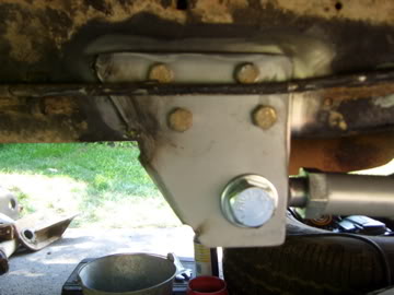 1989 Ford Bronco - A close-up view of a suspension bracket, likely part of a vehicle's undercarriage, with visible bolts and hardware.