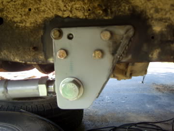 1989 Ford Bronco - Custom suspension bracket attached to the frame of a vehicle, with a tire in the foreground.