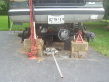 1989 Ford Bronco - Vehicle undergoing repairs, supported by jacks and blocks, with a visible license plate.