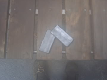 1989 Ford Bronco - Two metal brackets are shown on a wooden surface.