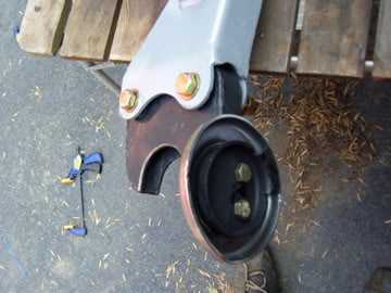 1989 Ford Bronco - Vehicle suspension part shown with hardware and a clamp on the ground.