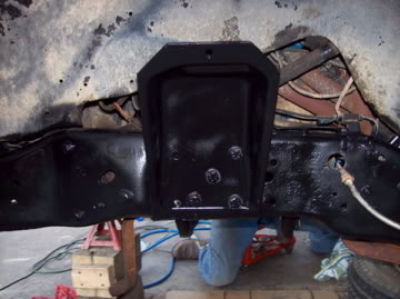 1989 Ford Bronco - This is a close-up view of a vehicle's frame with a newly painted black bracket. The vehicle is on jack stands.