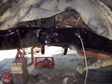 1989 Ford Bronco - Undercarriage view of a vehicle's frame and suspension system, supported by jack stands.