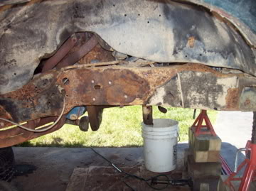 1989 Ford Bronco - Close-up of a heavily rusted vehicle frame, showing structural damage and a SuperMotors watermark.