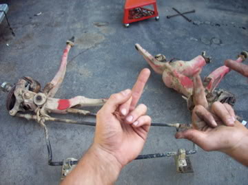 1989 Ford Bronco - Vehicle suspension parts are laid out on a concrete surface, with hands interacting with the components.
