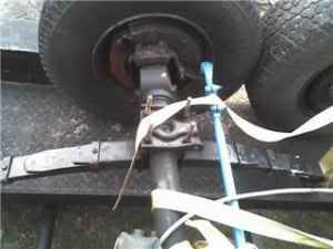 1989 Ford Bronco - Close-up view of a trailer axle assembly, showing suspension components and tires.