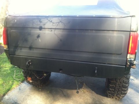 1989 Ford Bronco - The rear bumper and tire of a black SUV are visible in this image.