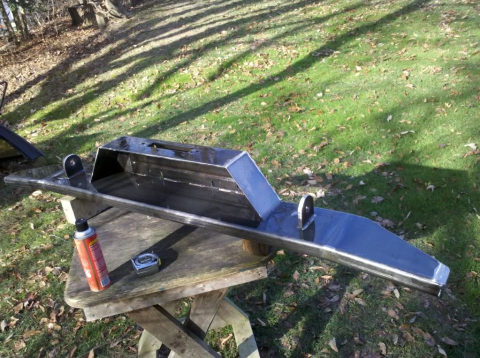 Custom steel bumper on a wooden table with a can of spray paint and a tape measure