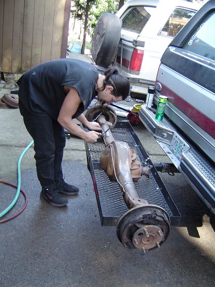 1988 Ford Bronco - A person is working on a vehicle's rear axle assembly, which is loaded onto a trailer.