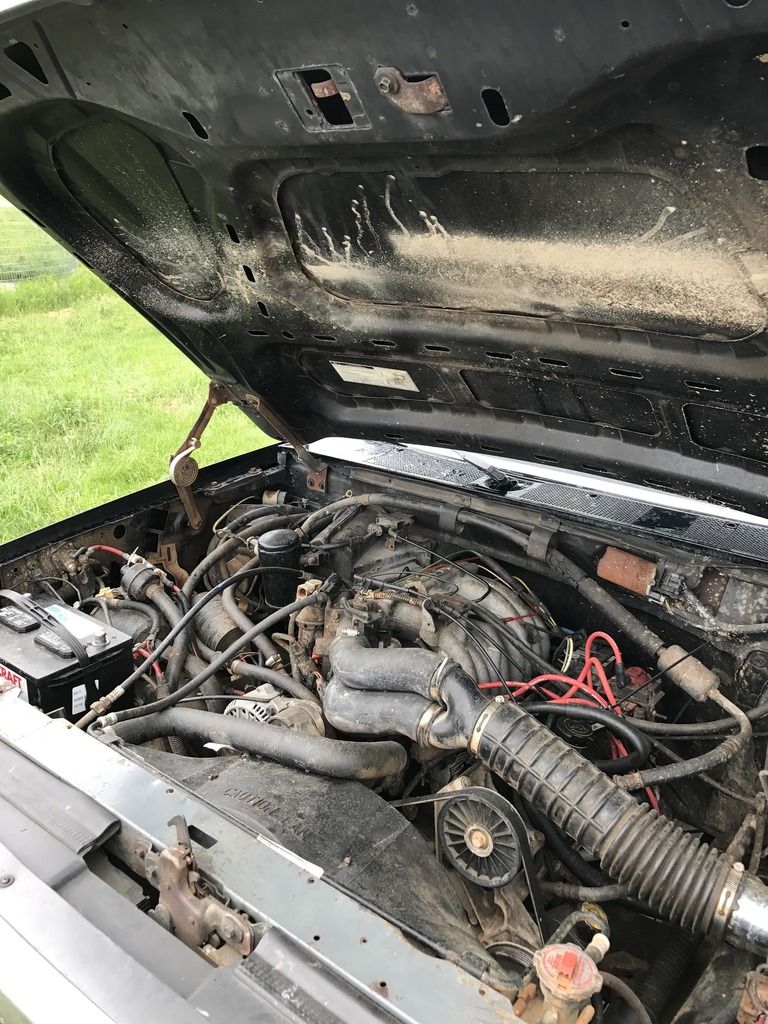 1992 Ford Bronco engine bay with hood open, showing engine components and battery