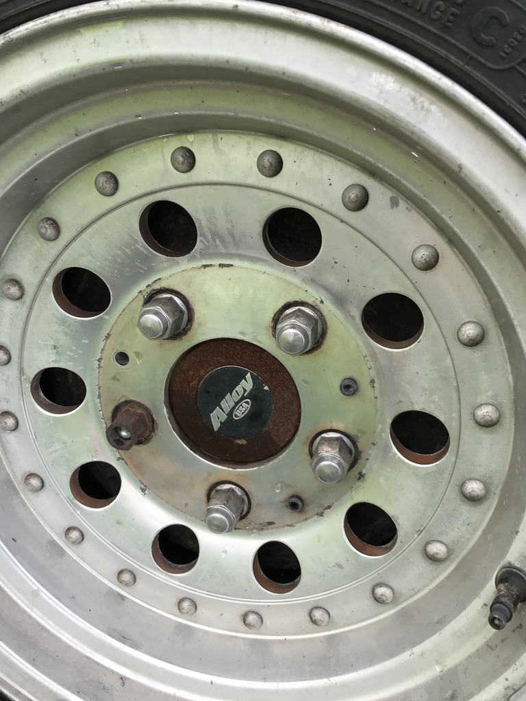 Close-up of an alloy wheel with multiple lug nuts and a center cap that says "Alloy USA"