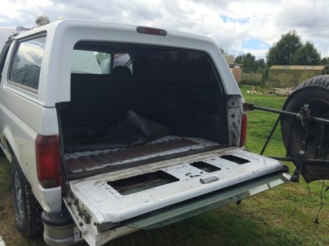 1993 Ford Bronco - Rear view of a 1993 Ford Bronco, showing the open cargo space and external spare tire mount.