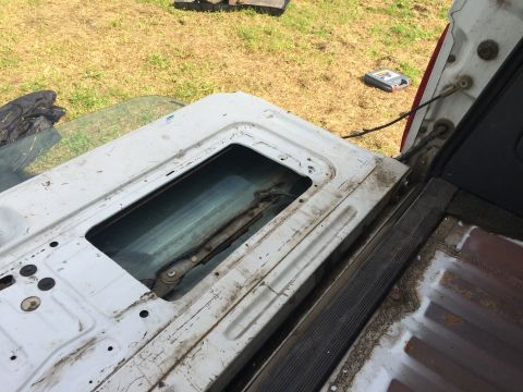 1993 Ford Bronco - The interior of a vehicle's tailgate is shown with the window removed, revealing the internal mechanism.