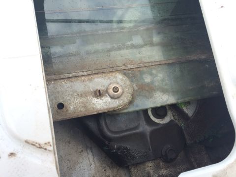 1993 Ford Bronco - Close-up of a vehicle's window regulator mechanism, showing signs of wear and rust.