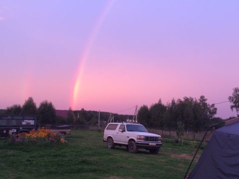1993 Ford Bronco - A white 1993 Ford Bronco is parked in a field during sunset with a rainbow overhead.