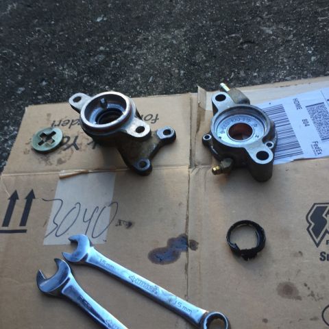 1985 Ford F-350 - Vehicle parts laid out on cardboard with tools and oil stains, possibly for repair.