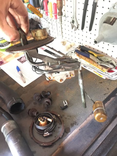 1985 Ford F-350 - Disassembled fuel pump assembly and related parts laid out on a workbench for repair.