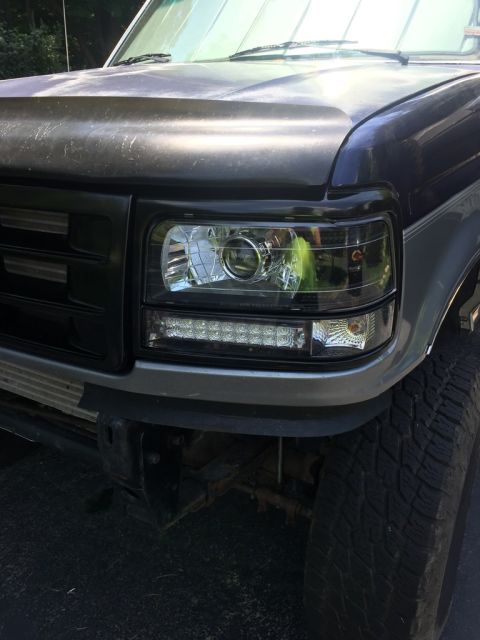 1985 Ford F-350 - Close-up of a truck's front end, highlighting the grille and updated headlights with integrated LED daytime running lights.