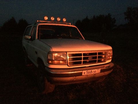 1993 Ford Bronco - This SUV has a roof rack with four lights and a license plate with Cyrillic characters.
