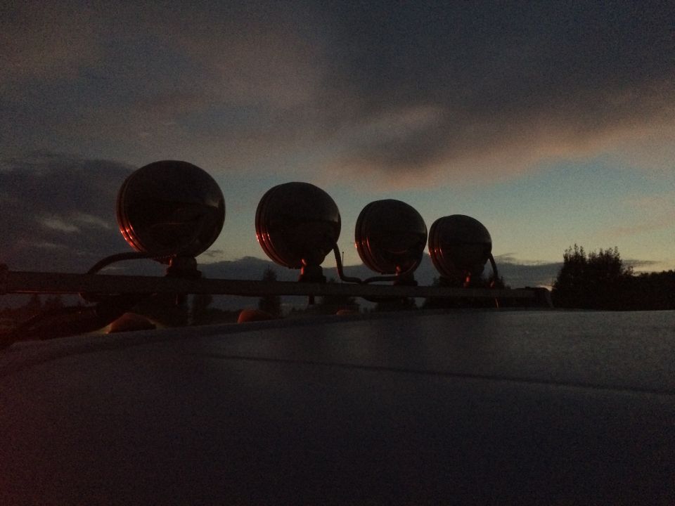 Roof rack with four round lights against a dusky sky
