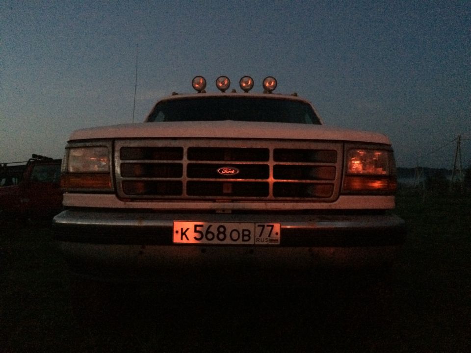 Front view of a 1992-1997 Ford F-Series truck with quad headlights and a horizontal grille. Four auxiliary lights are mounted on the roof